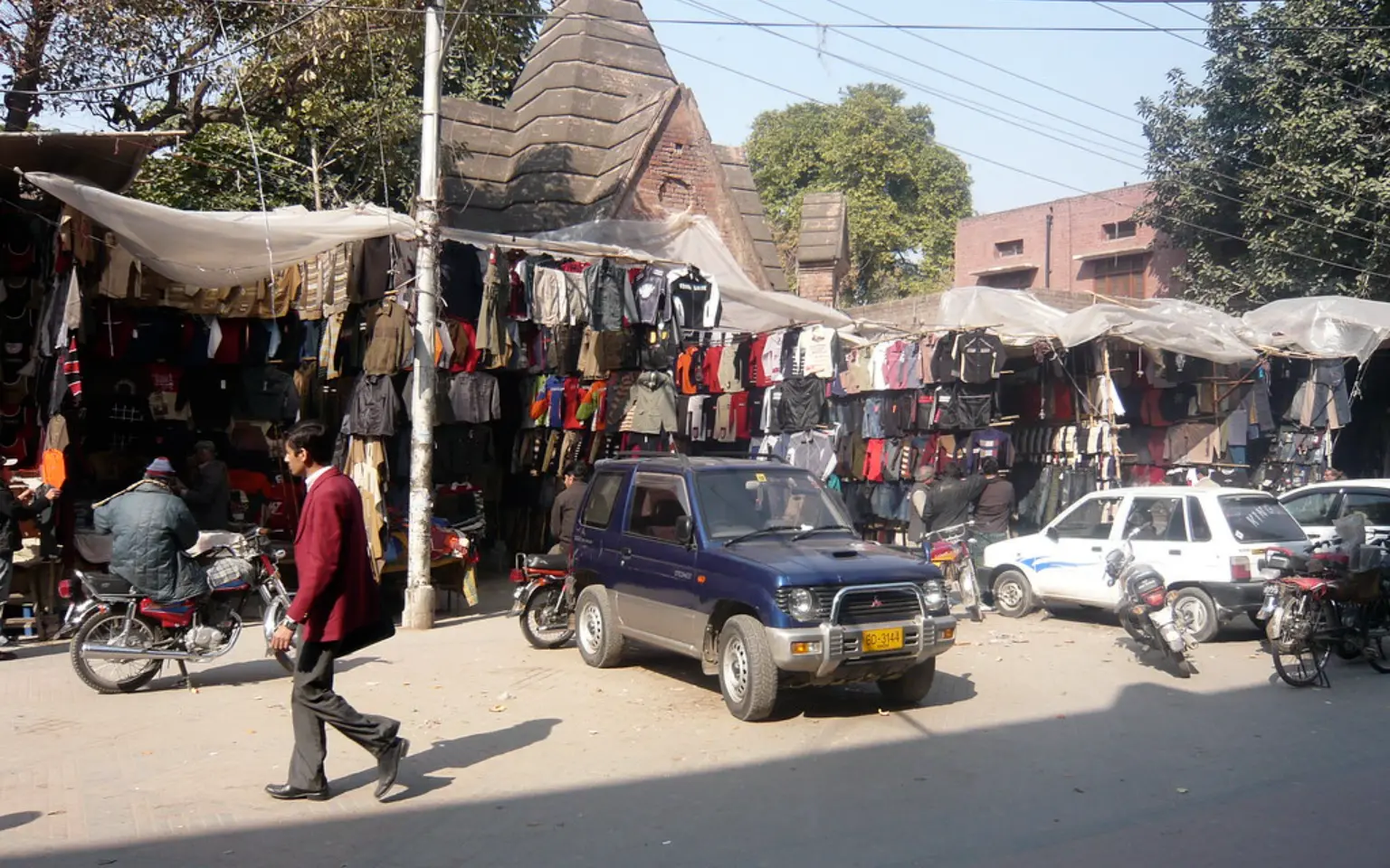 Awnings and parked traffic along the shopfronts of Anarkali, Lahore