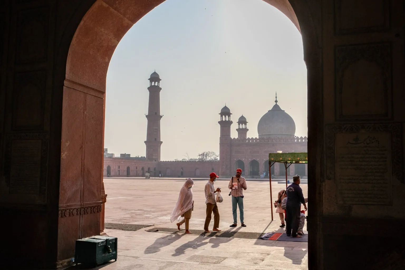 The Badshahi Mosque framed through a red sandstone archway in Lahore