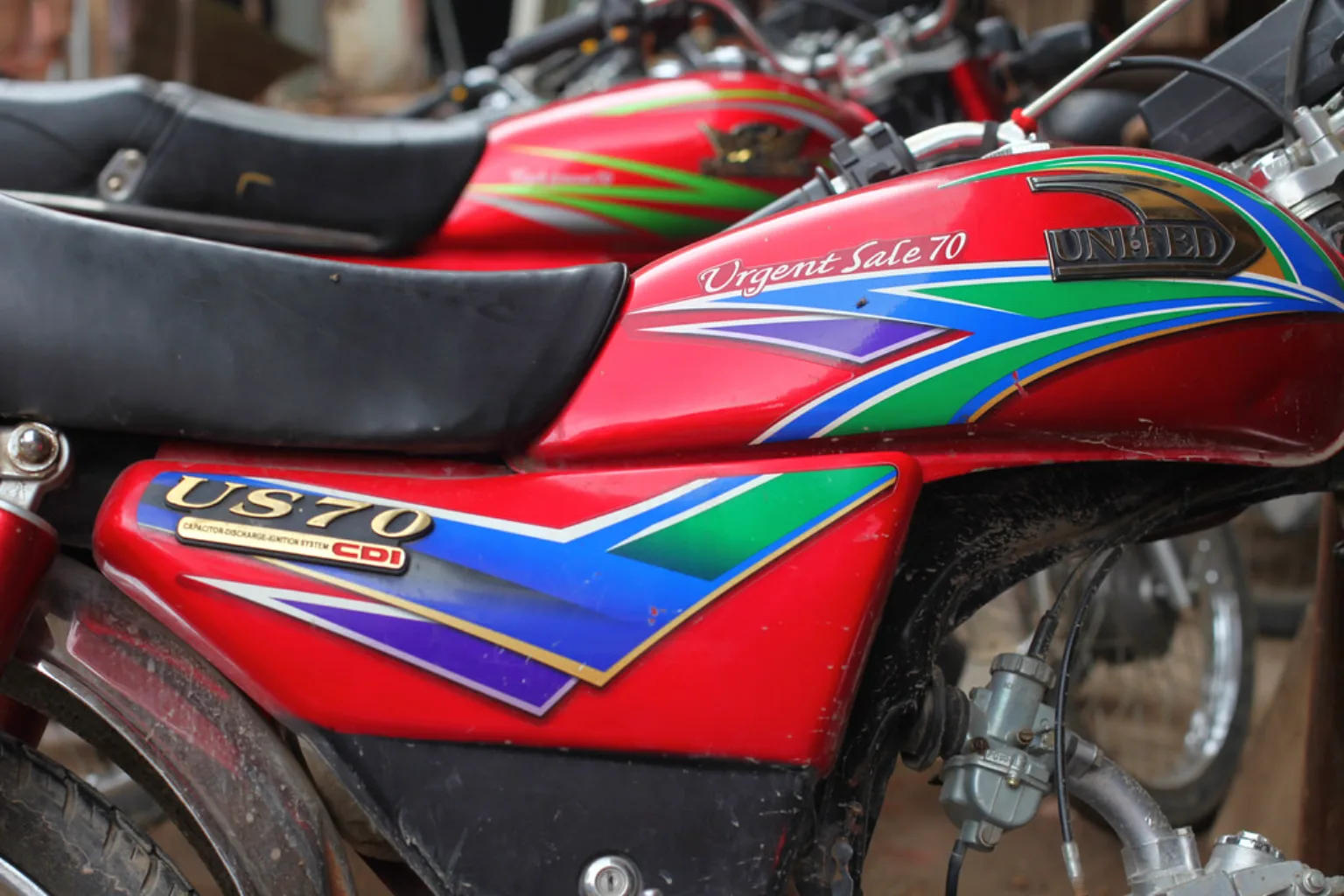 A bright red 70cc motorcycle of the kind ridden across Lahore