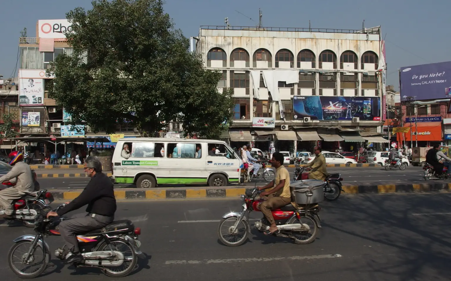 Motorbikes crossing a wide road in Lahore