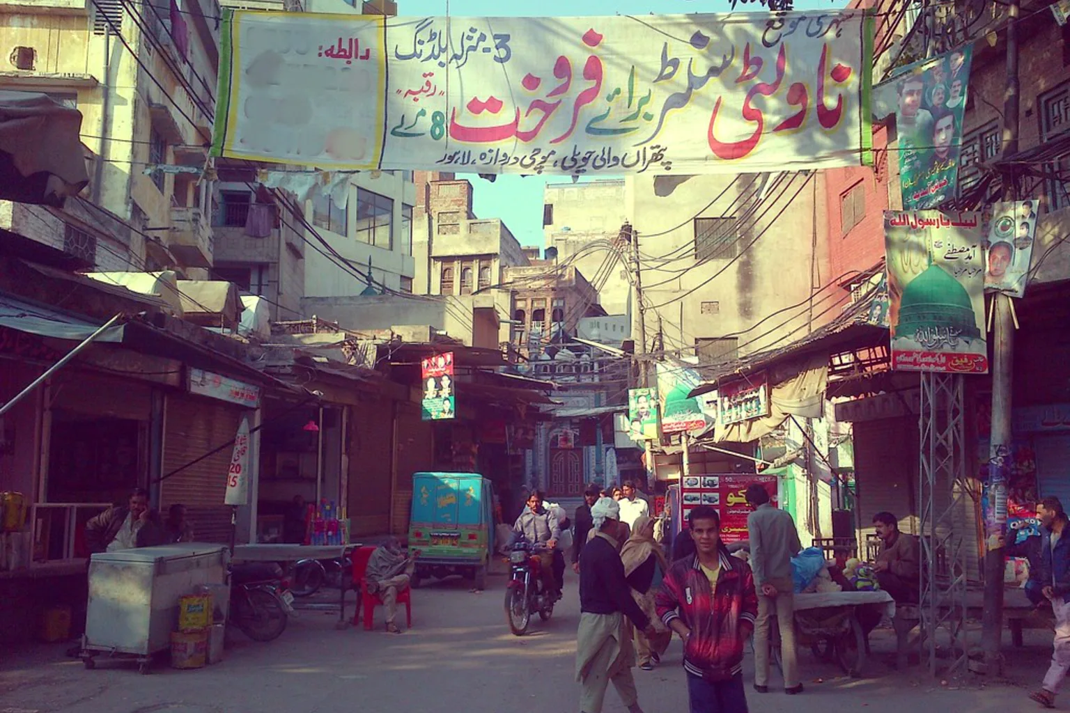 A bazaar lane inside Mochi Gate, Lahore, hung with Urdu shop signboards