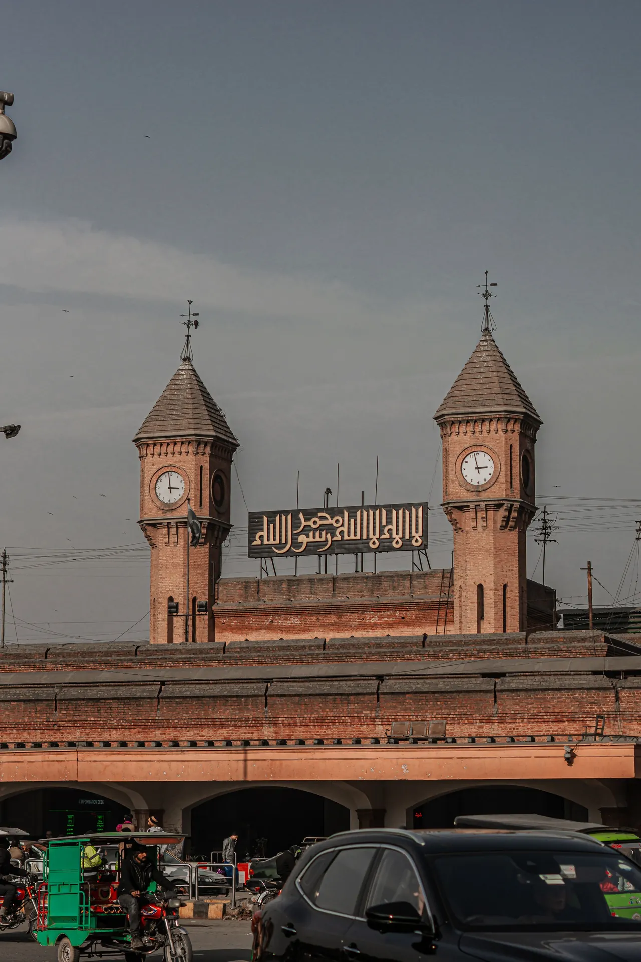 The clock towers of Lahore Railway Station above busy street traffic